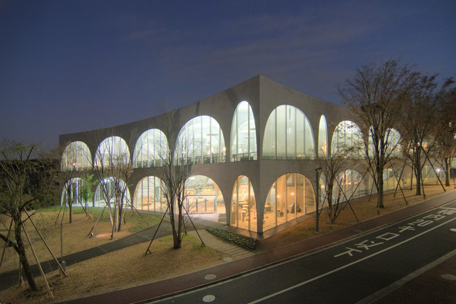 Toyo Ito's arched library at Tama Art University, lit up at dusk